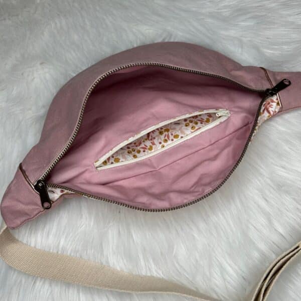 sac banane en tissu lin de couleur rose poudré et un tissu fleuri avec anse réglable écrue et une poche intérieure zippée